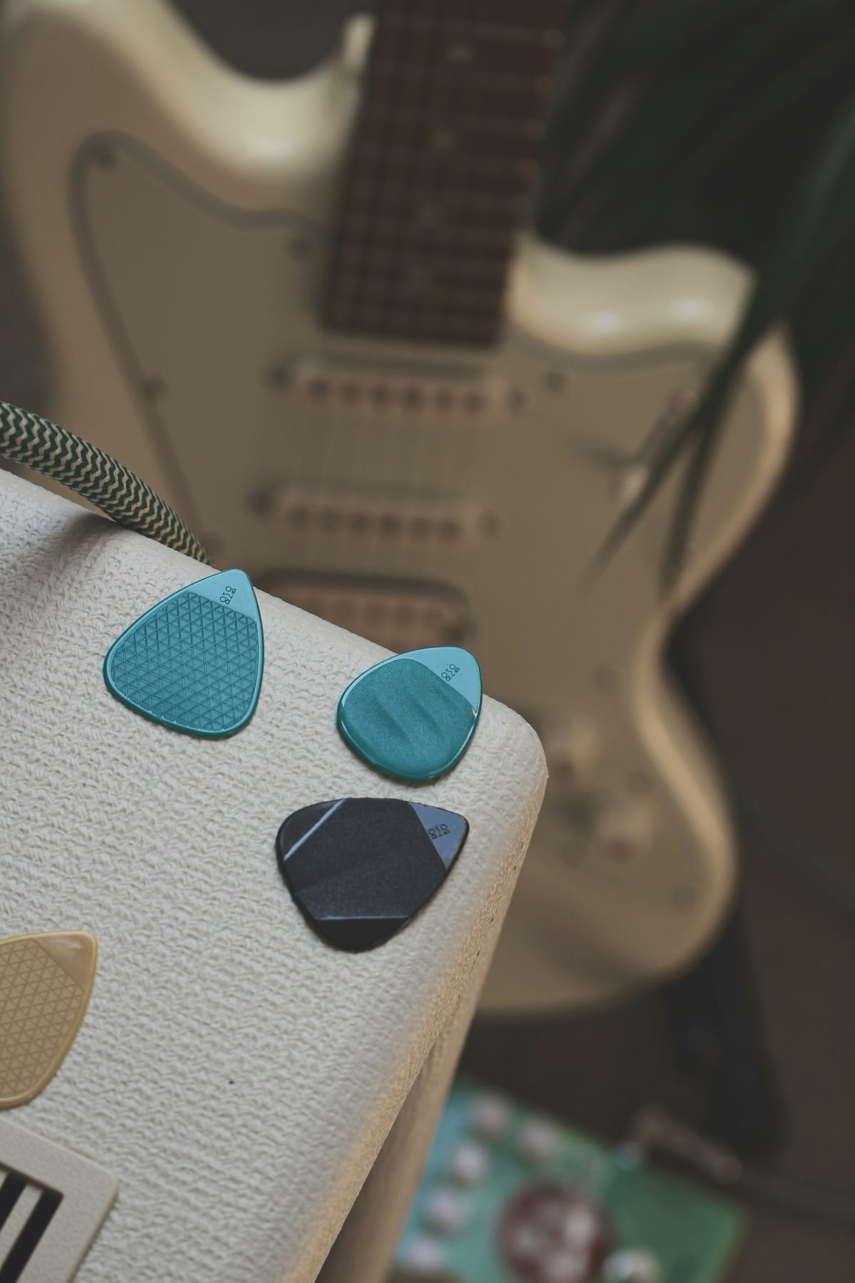 Close detail of guitar picks and small playing accessories on a plain surface