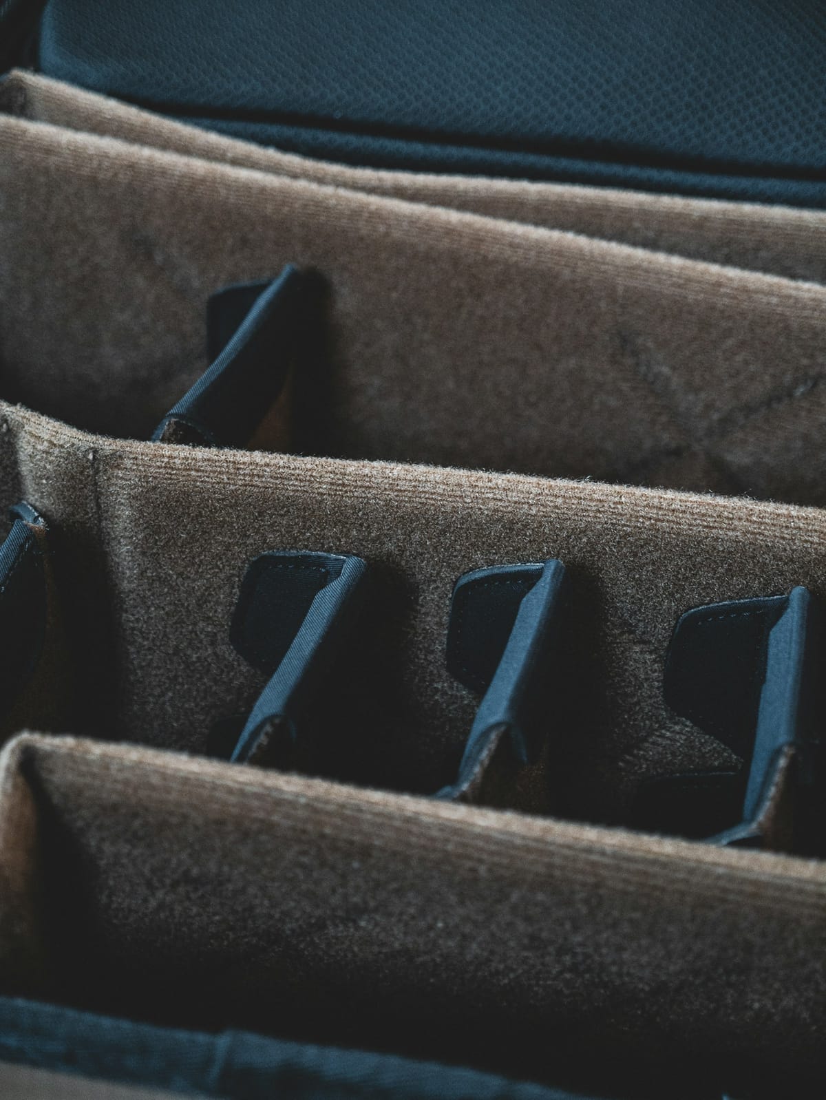 Padded instrument case compartments arranged in an ordered row