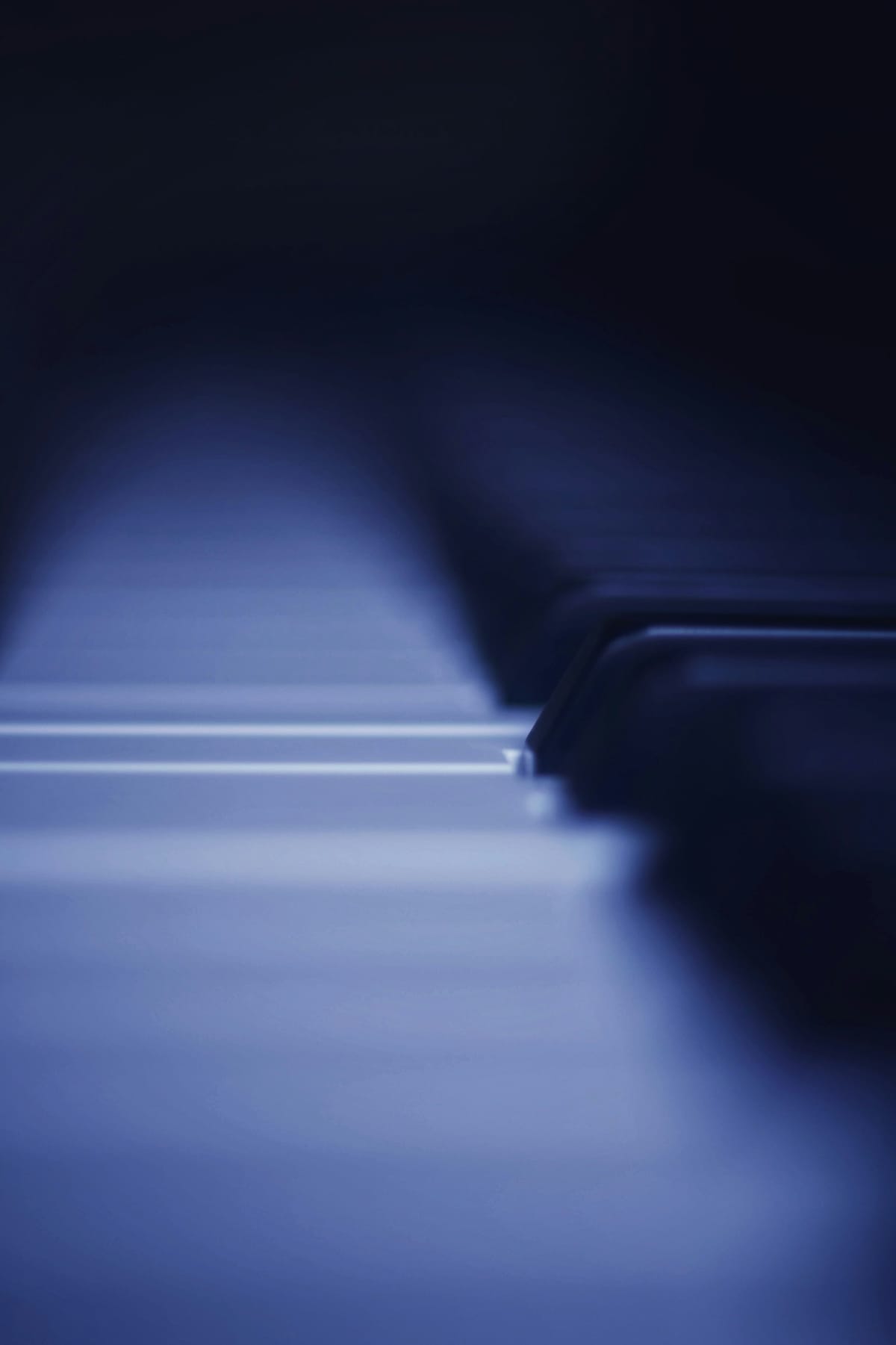 Detail of piano keys photographed at an angle with soft directional light