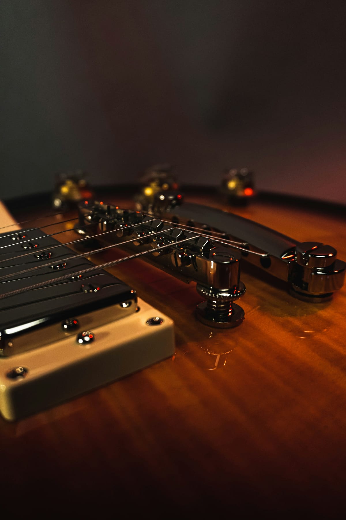 Macro detail of electric guitar pickups and strings on a dark finish