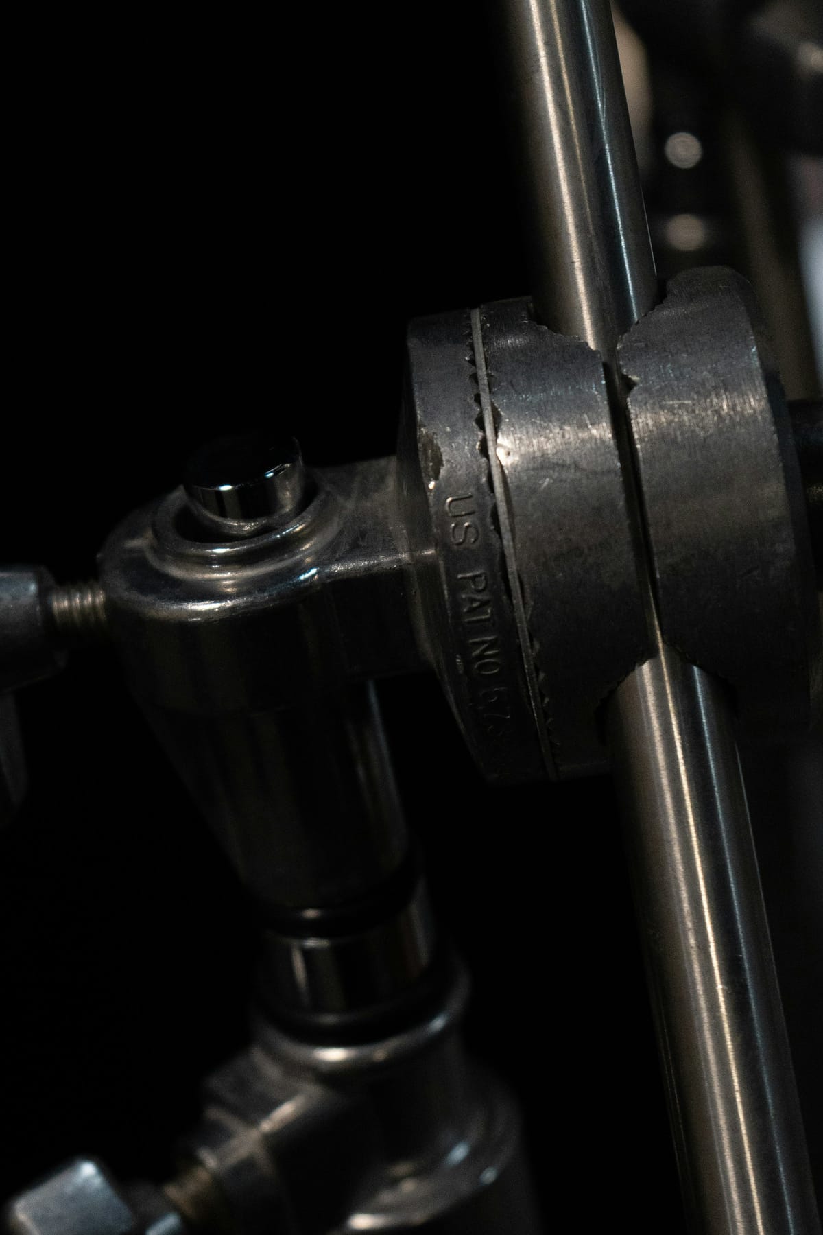 Close detail of cymbal stand hardware and tension fittings in a neutral environment